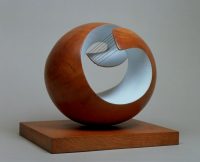Pelagos, a round sculpture from elm wood with the center painted light blue and six strings connecting 2 portions