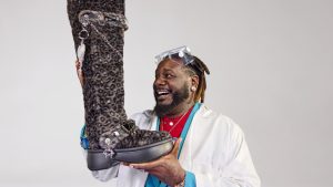 T-Pain holding the Crocs Unfurgettable Leopard Knee High Boot